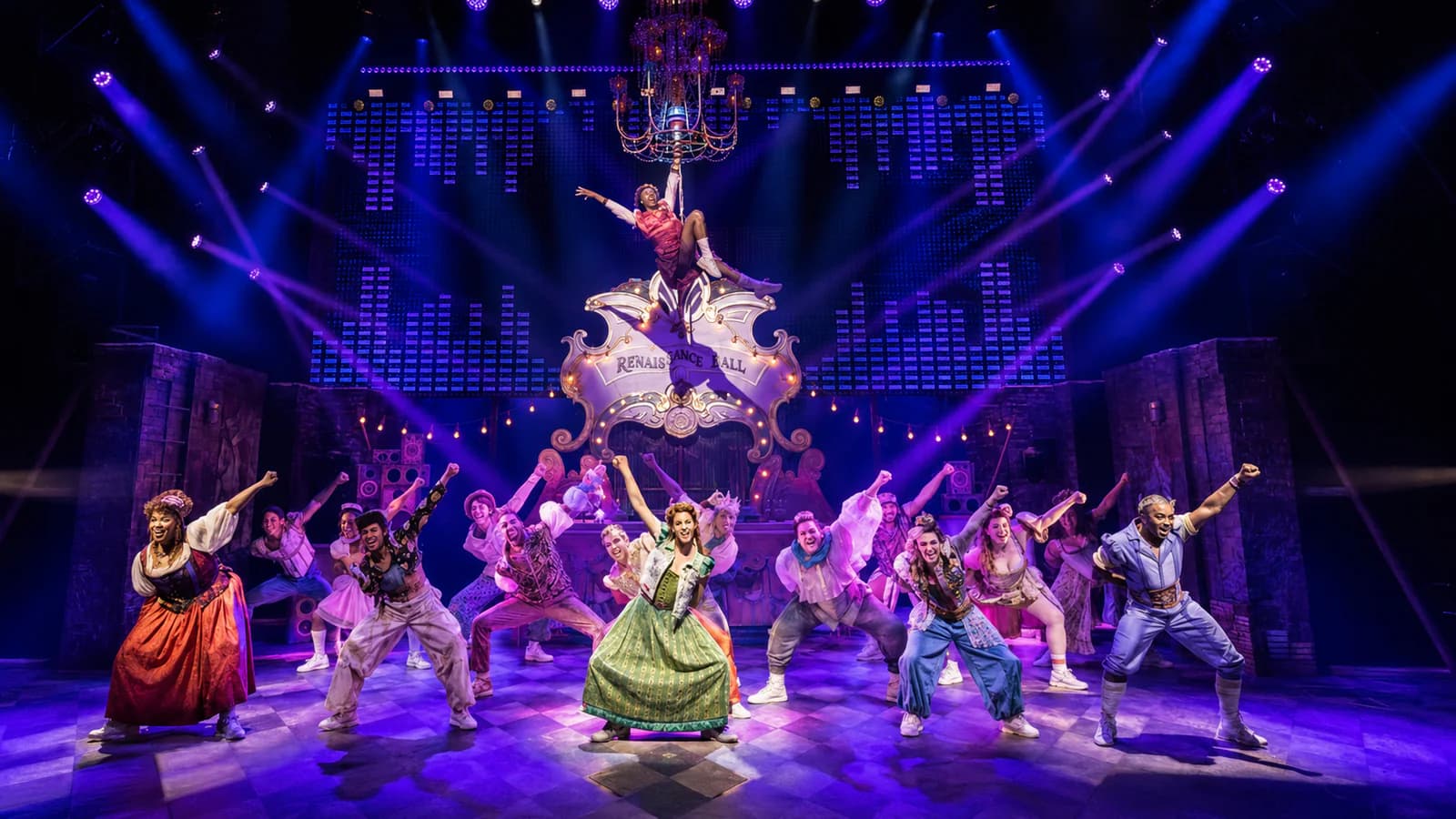Purple and blue moving-head effects above a live theatre ensemble