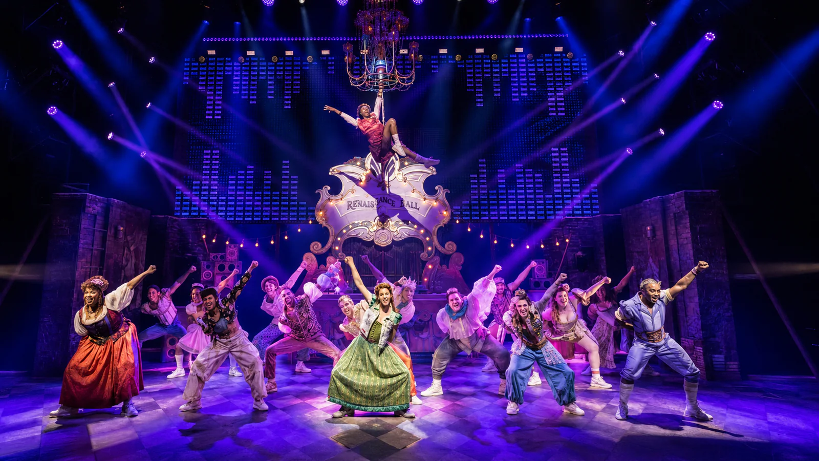 Purple and blue moving-head effects above a live theatre ensemble